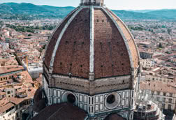 Aerial view of the Florence Cathedral with its large red dome and surrounding cityscape.